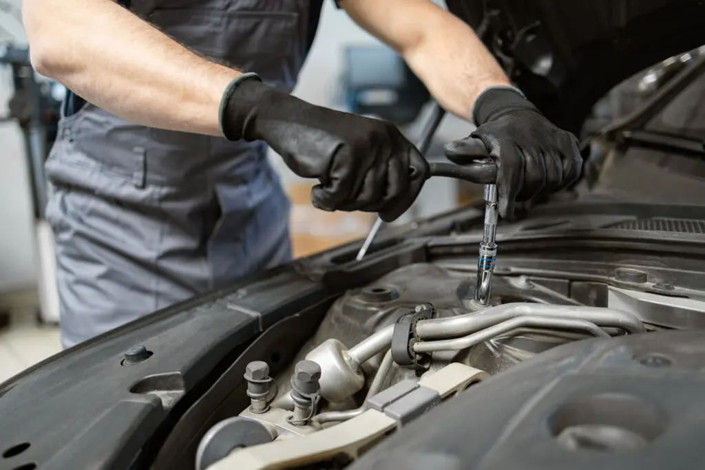 auto mechanic working on car engine in auto repair shop