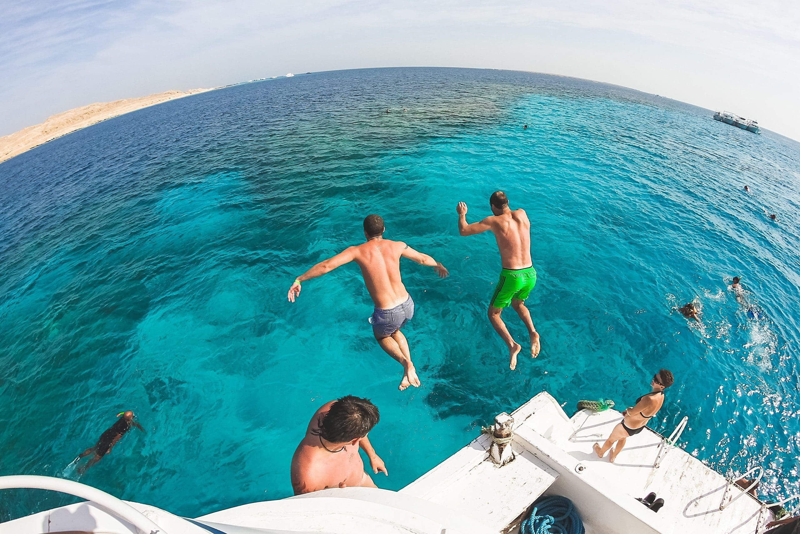 Men jumping into ocean off boat