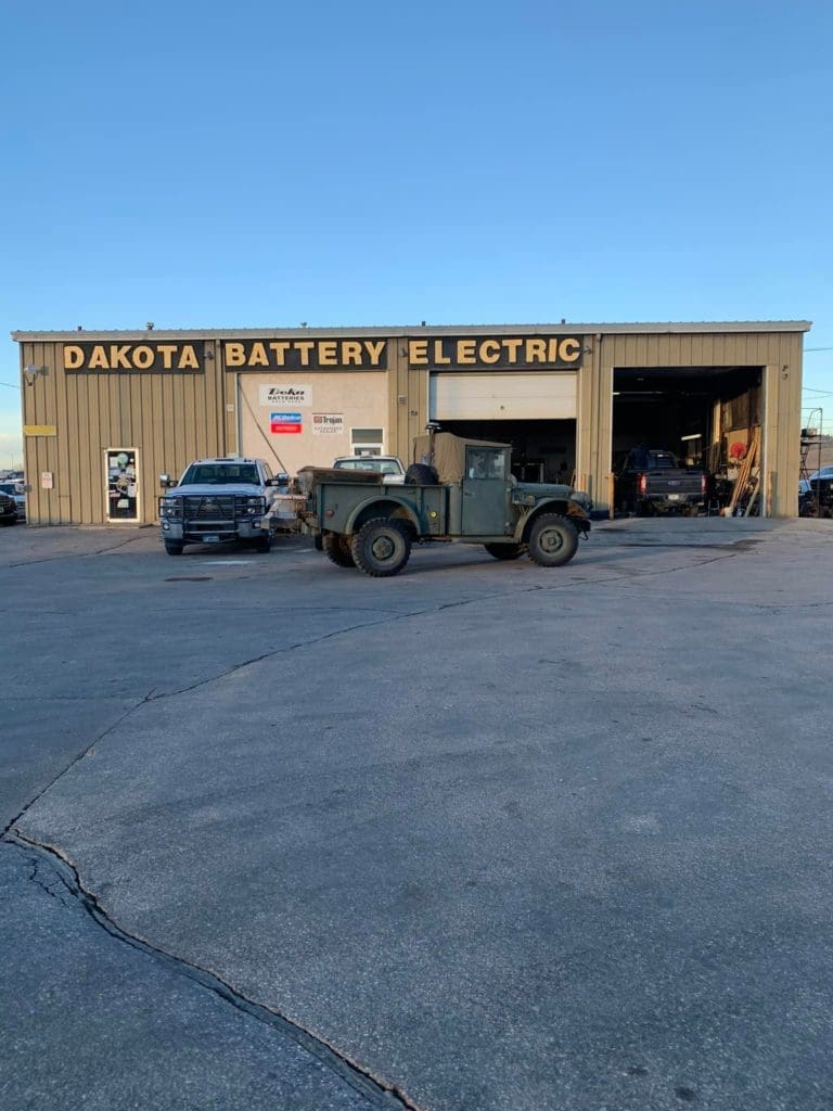 1954 Military gray Power Wagon in front of Dakota battery electric building